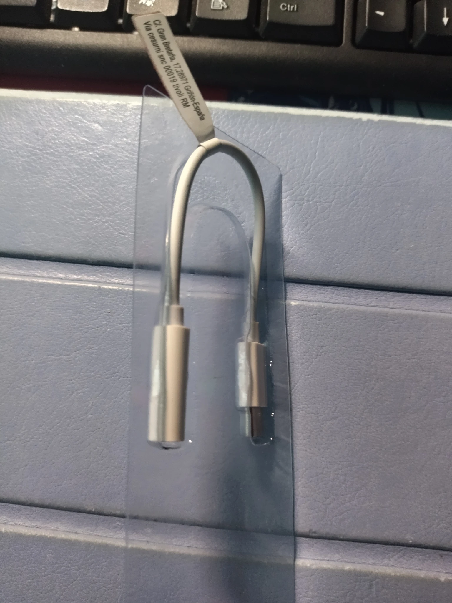 Foto dell'adattatore inserito nel supporto interno della confezione, si nota che il filo tende a uscire fuori perché lo spazio è mal misurato