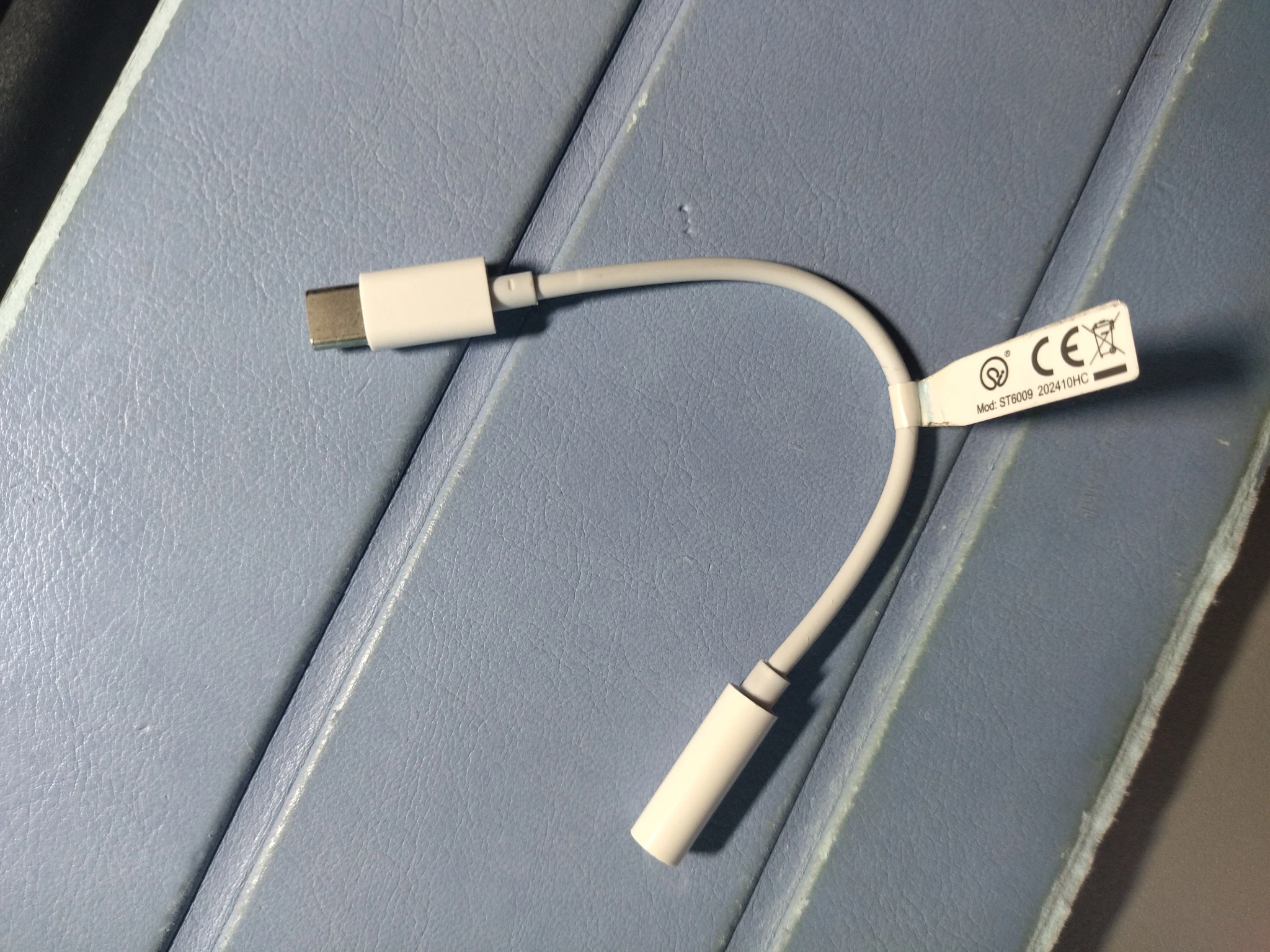 Foto dell'adattatore bianco spacchettato appoggiato su una superficie